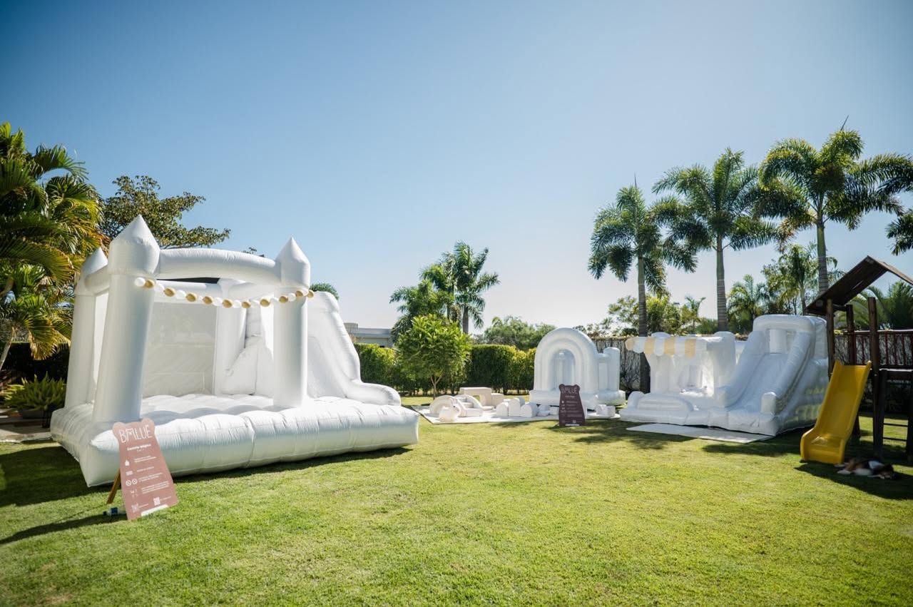 Montagem real da Baluê com castelos infláveis brancos em um jardim em Itu